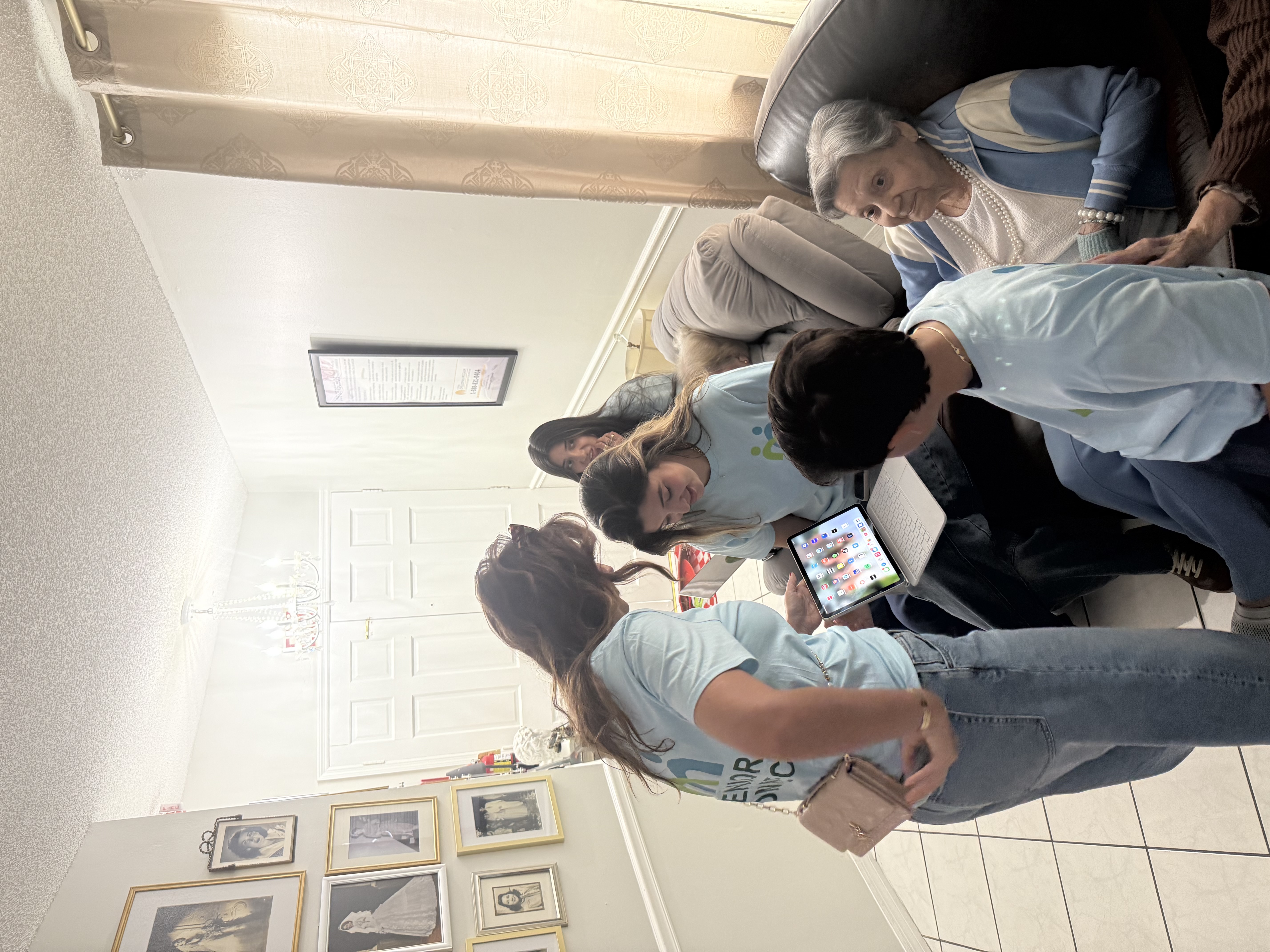 Senior Connect volunteers showing a tablet to residents during a visit